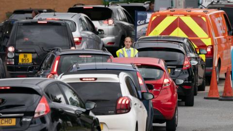 People queue for fuel at a petrol station in Barton, Cambridgeshire