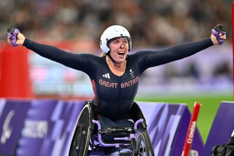 Hannah Cockroft celebrates after crossing the line to win a gold medal at the 2024 Paralympic Games