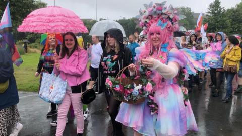 People in pink and blue taking part in the march on Saturday