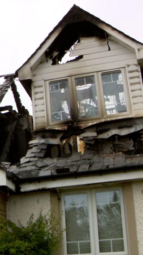 White house with burned roof and fire damage