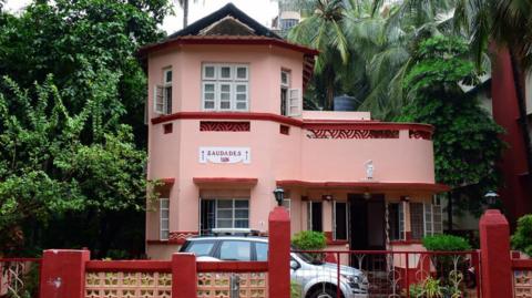 The pink facade of the Saudades art deco-style family bungalow, built in 1936 in Mumbai's Bandra suburb, features local elements like lattice balcony screens.