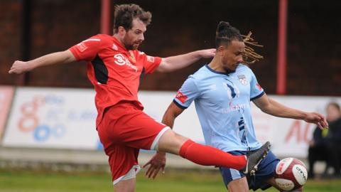 Bridlington Town player in red tackles an opposing player