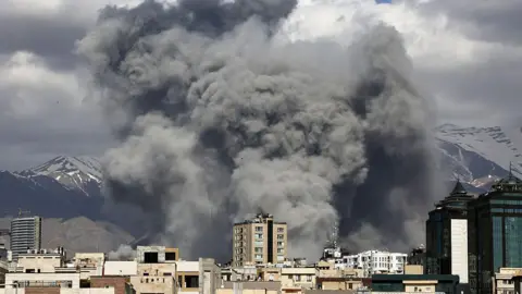  Plumes of smoke rise following reported explosions in Tehran on March 1, 2026
