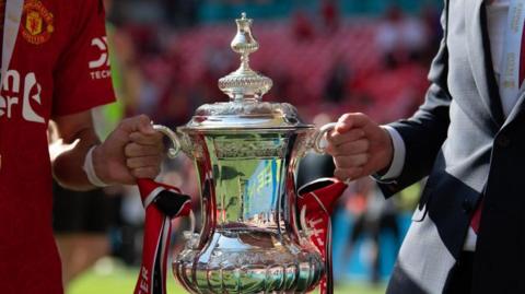 Erik ten Hag and Bruno Fernandes holding the FA Cup trophy earlier this year