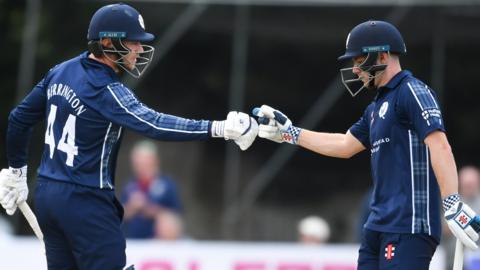 TWo Scotland players touch gloves