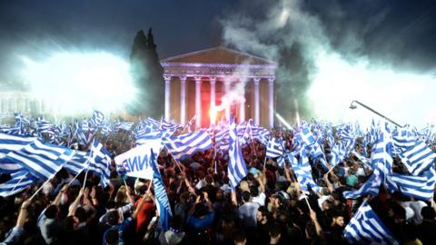 Supporters of New Democracy leader Antonis Samaras wave flags during a pre-election speech in Athens, 3 May 2012