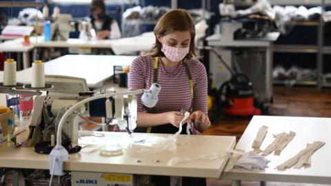 A female factory worker at a sewing machine