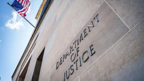 A US flag flies on the side of the US Department of Justice headquarters building on 15 September 2024, in Washington DC.