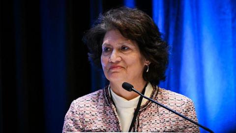 Judge Gonzalez Rogers appears on a panel wearing a tweed jacket and white turtleneck