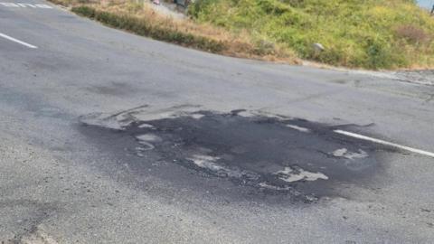 A black and burnt section on a road in Guernsey.
