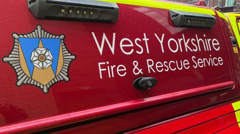 The West Yorkshire Fire and Rescue Service logo on the side of a van. 