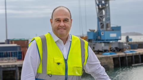 Ross Coppolo in a white shirt and yellow high-vis vest