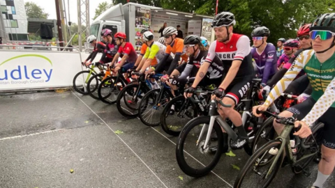 A row of cyclists poised at a start line