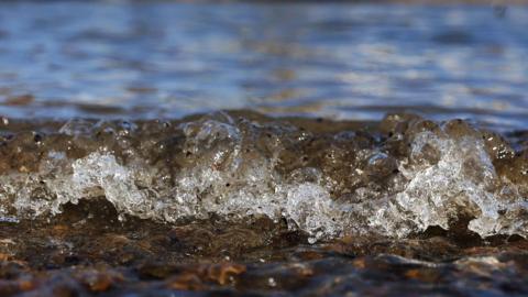 Water from the River Thames breaking against the shore