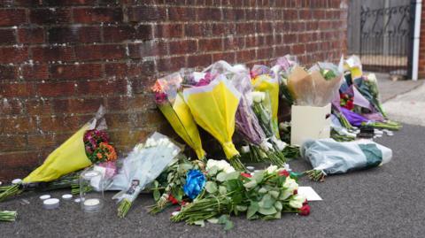 Flowers left near the scene in Midhurst Gardens in Uxbridge.