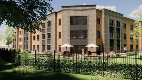 An artist's digital impression of the new care home in Northallerton - a large brown brick building surrounded by grounds and a patio, with iron railings around the outside.