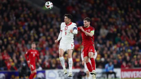 Wales' Ben Davies challenges Poland's Robert Lewandowski