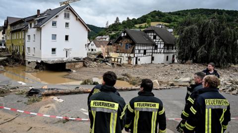 Firefighters stand at a damaged area of the village of Schuld in the district of Ahrweiler after heavy flooding of the river Ahr, in Schuld, Germany, 15 July 2021.