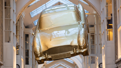 A handcrafted golden hanging sculpture, inspired by the iconic Aston Martin DB5