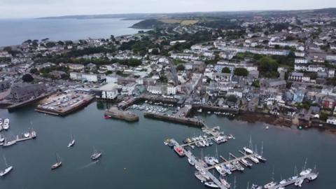 An aerial view of the docks and Falmouth showing parts of the harbour, the docks, boats and buildings. 