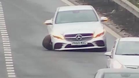 Car with badly damaged wheel on the M1.