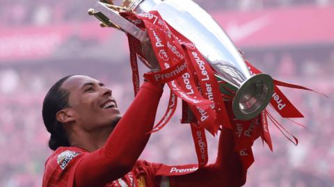 Liverpool captain Virgil van Dijk lifts the Premier League trophy as the team celebrate their 2024-25 title win at Anfield