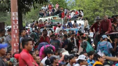 Dozens of migrants are pictured waiting