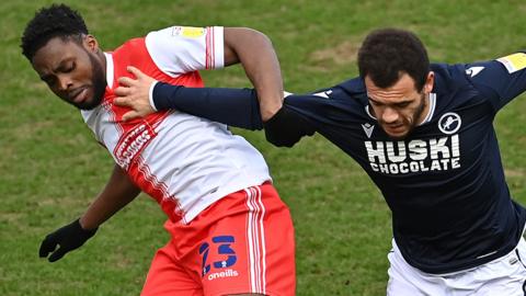 Fred Onyedinma and Mason Bennett battle for the ball