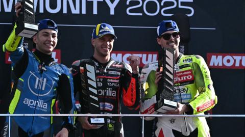 Marco Bezzecchi flanked by Raul Fernandez (left) and Fabio Di Giannantonio on the MotoGP podium in Valencia