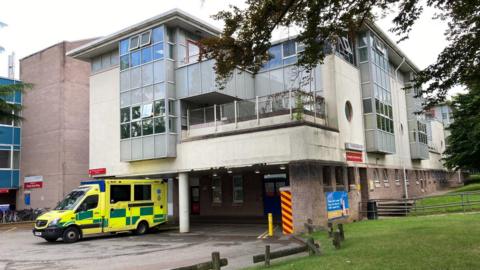 The outside of Cheltenham General Hospital building with an ambulance outside. 