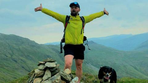 Jaroslaw Ringart on top of a fell with a dog