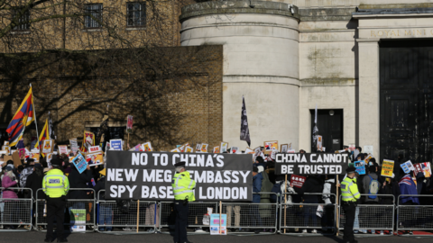 Protesters gather outside the Royal Mint, the proposed site of a new Chinese embassy, carrying signs during a demonstration