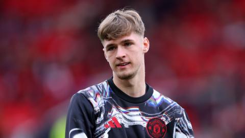 Tyler Fletcher warming up before a Manchester United Premier League game