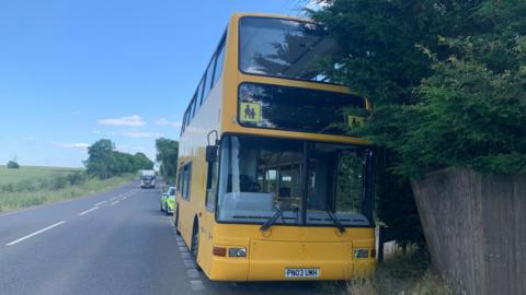 The yellow school bus parked on the A5 with a police car nearbu