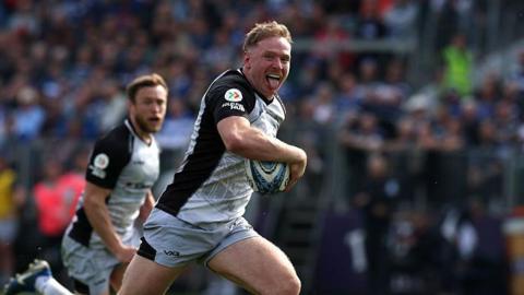 Connor Doherty with his tongue out as he runs in to score a try for Newcastle