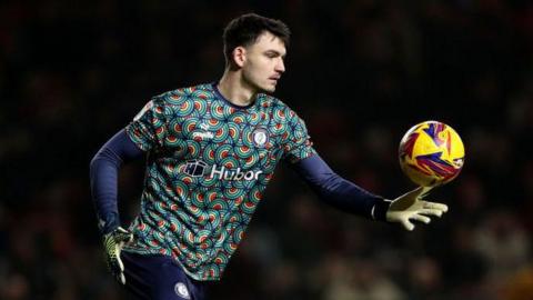 Max O'Leary goes to kick the ball out of his hand during a match