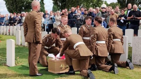 Members of 330th Brigade of the Royal Field Artillery, lower a coffin at a Commonwealth War Graves cemetery in Belgium.