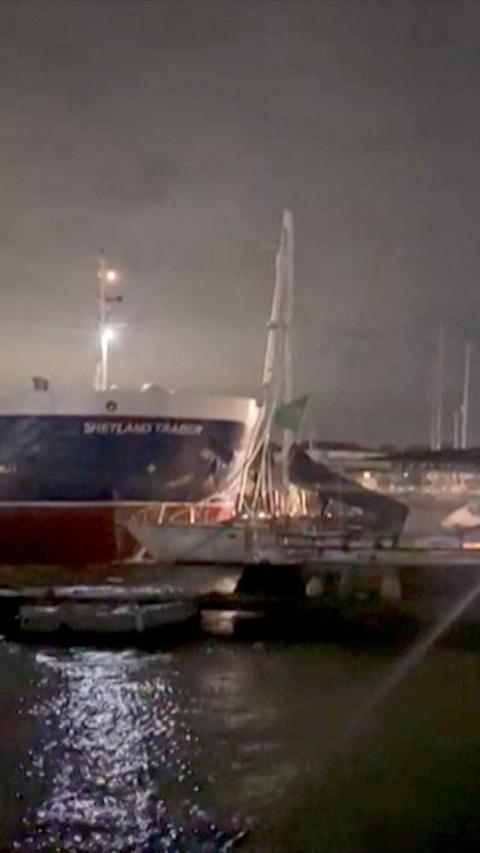 A large boat strikes a yacht in a river at night
