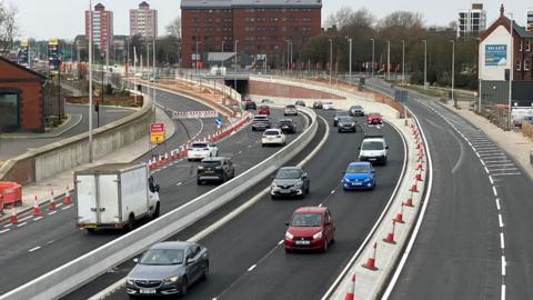 Multiple vehicles travelling in both directions on the new A63 underpass.