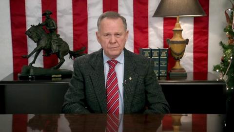 Roy Moore speaking at a desk