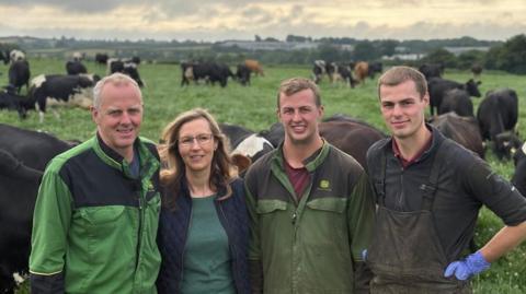 The Jones family smile for the camera in front of their cow paddock