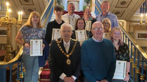 Eighty-year-old Ted Sturgeon meets leisure centre workers who saved his life when he had a heart attack. He is standing next Lord Mayor of Liverpool Richard Kemp who is wearing his ceremonial chain