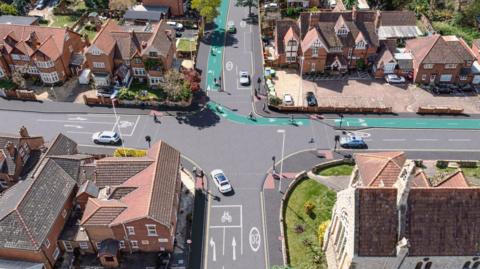 A 3D visual image of a birds eye view of Stroud Road adjoining King Edwards Avenue in Gloucester, A green cycle path runs through some of the road.