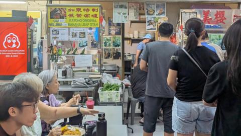 People line up at nearby shop at the food centre on Monday 