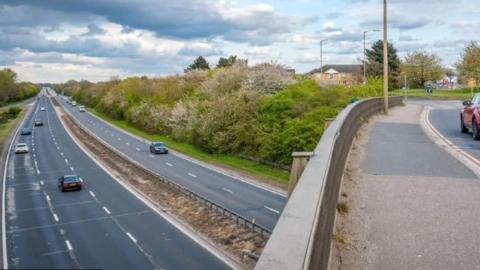 A12 from the vantage point of a bridge, showing a few cars travelling northbound and southbound on the road.