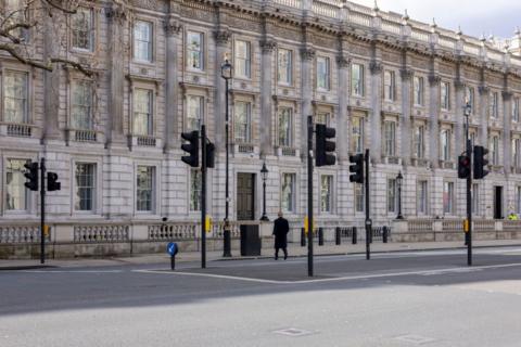 A lone man crosses Whitehall and Parliament street during the middle of the day towards the Cabinet Office in Westminster