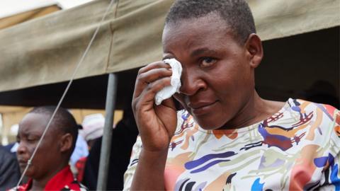 A female survivor uses a tissue to wipe tears from her eyes during a memorial service held for victims of the capsized ferry at Nyamhunga Stadium in Kariba - 13 August 2026
