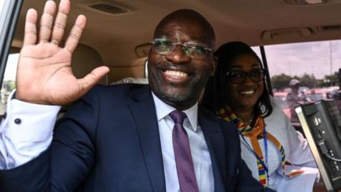 Charle Ble Goude, former right-hand man to ex-president Laurent Gbagbo waves from his car upon his arrival at Felix-Houphouet Boigny airport in Abidjan on November 26, 2022