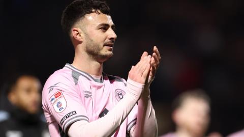 Aaron Collins applauds the MK Dons supporters