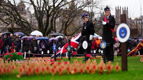 Veterans marked the silence in front of the Scott Monument overlooking a field of poppy's in Edinburgh, standing in old military uniforms as a crowd of onlookers pay their respects.